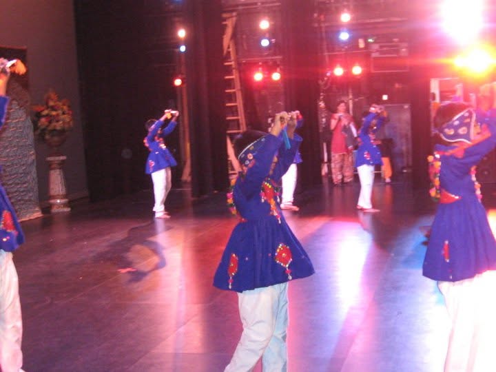 Noopur students performing folk choreography in blue costumes