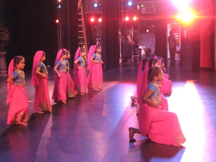 Noopur students performing in pink costumes on stage