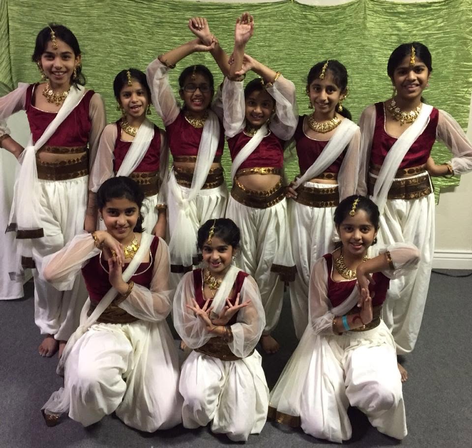 Noopur students posing together in coordinated maroon and white costumes